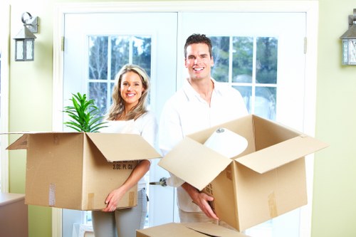 House movers carrying furniture through a Crystal Palace home entrance